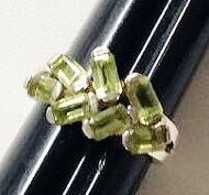 Handcrafted sterling silver ring from Nepal featuring a cluster of genuine bezel-set faceted green Peridot gemstones in a unique artisan design.