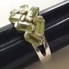 Angled view of the handcrafted sterling silver Peridot ring highlighting the cluster of bezel-set faceted gemstones.